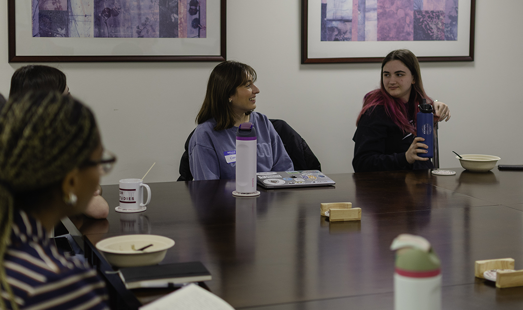 students talk around a table